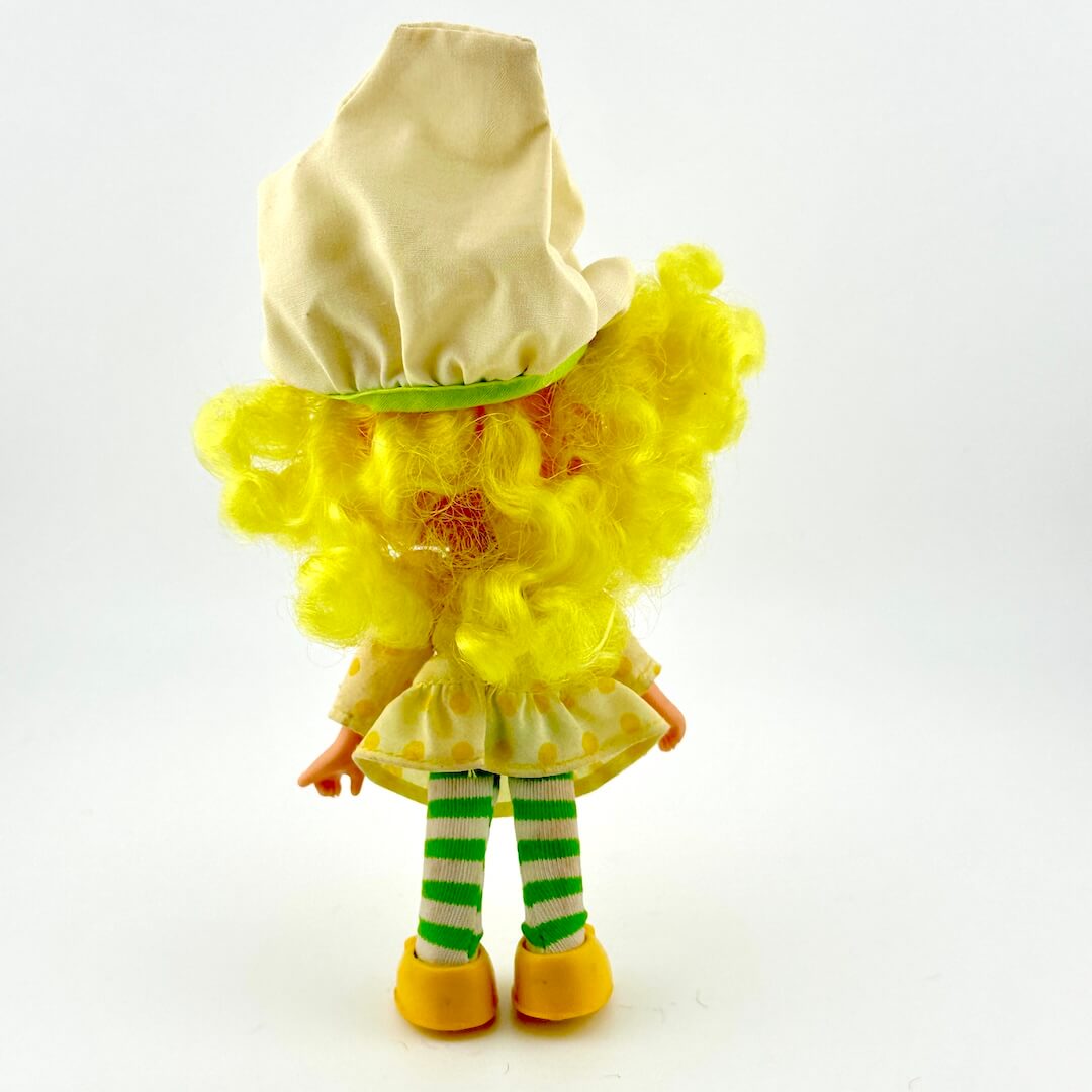 Toy figure with yellow hair and outfit on a white background