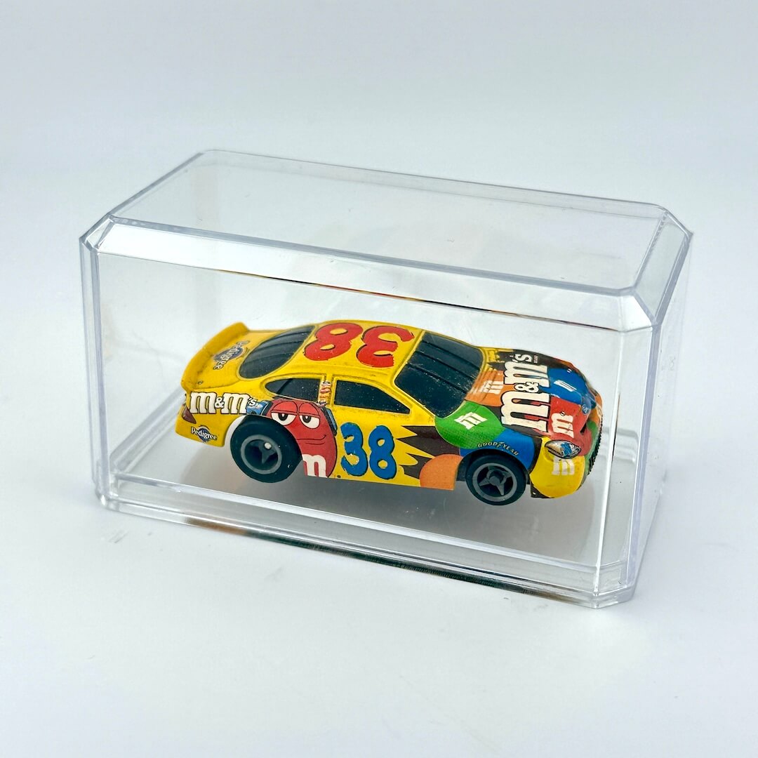 Colorful toy race car inside a clear display case on a white background