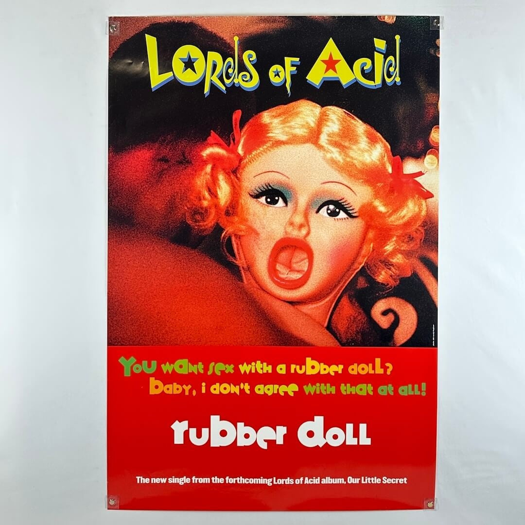 Vintage-style album cover with a woman's face and text, featuring the title 'Lords of Acid' and 'Rubber Doll'.