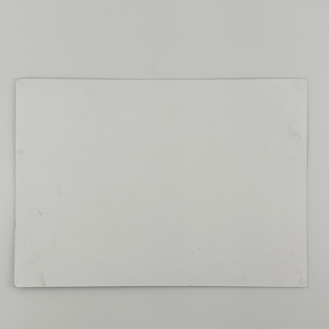 Reverse side of white, rectangular card showing slightly softened corners and some ink transfer.
