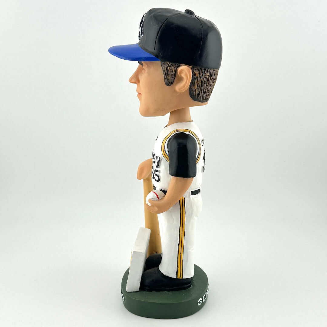 Bobblehead figure of a baseball player in a black and blue cap, white and black uniform with gold accents, holding a bat on a white background.