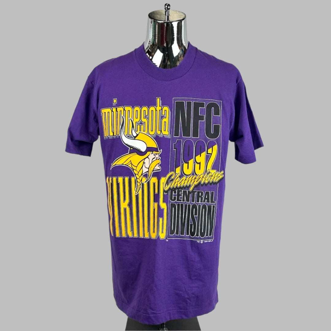 Purple short sleeved t-shirt with team logo by yellow & black text for, "MN Vikings NFC 1992 Champions, Central Division."