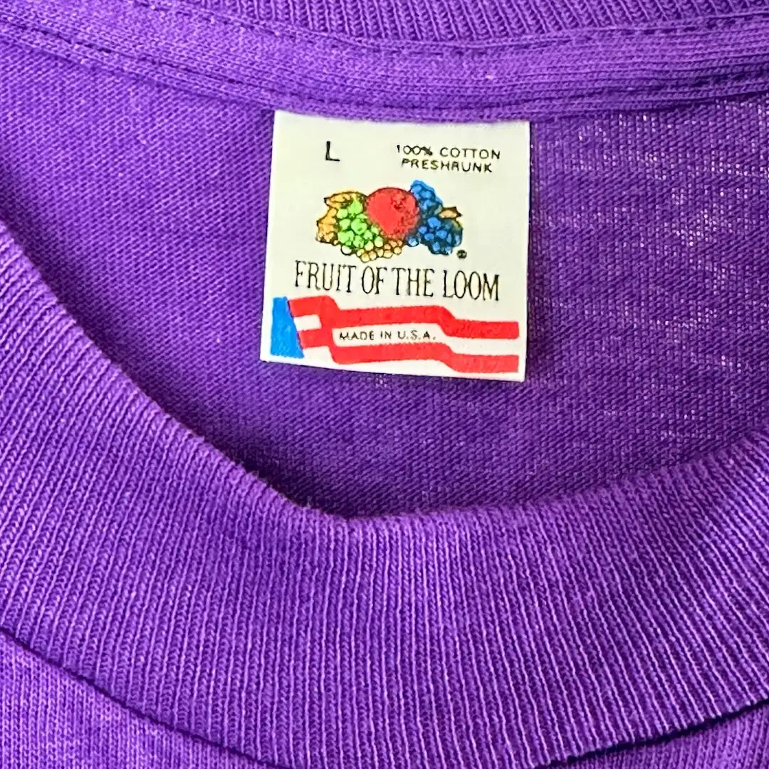Close up of neck tag showing Fruit of the Loom logo, made in USA, pre-shrunk cotton, size L.