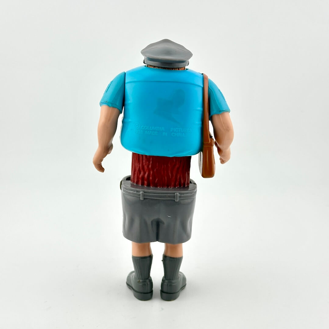Action figure of a character wearing a blue shirt, red pants, gray shoes, and a gray cap on a white background.