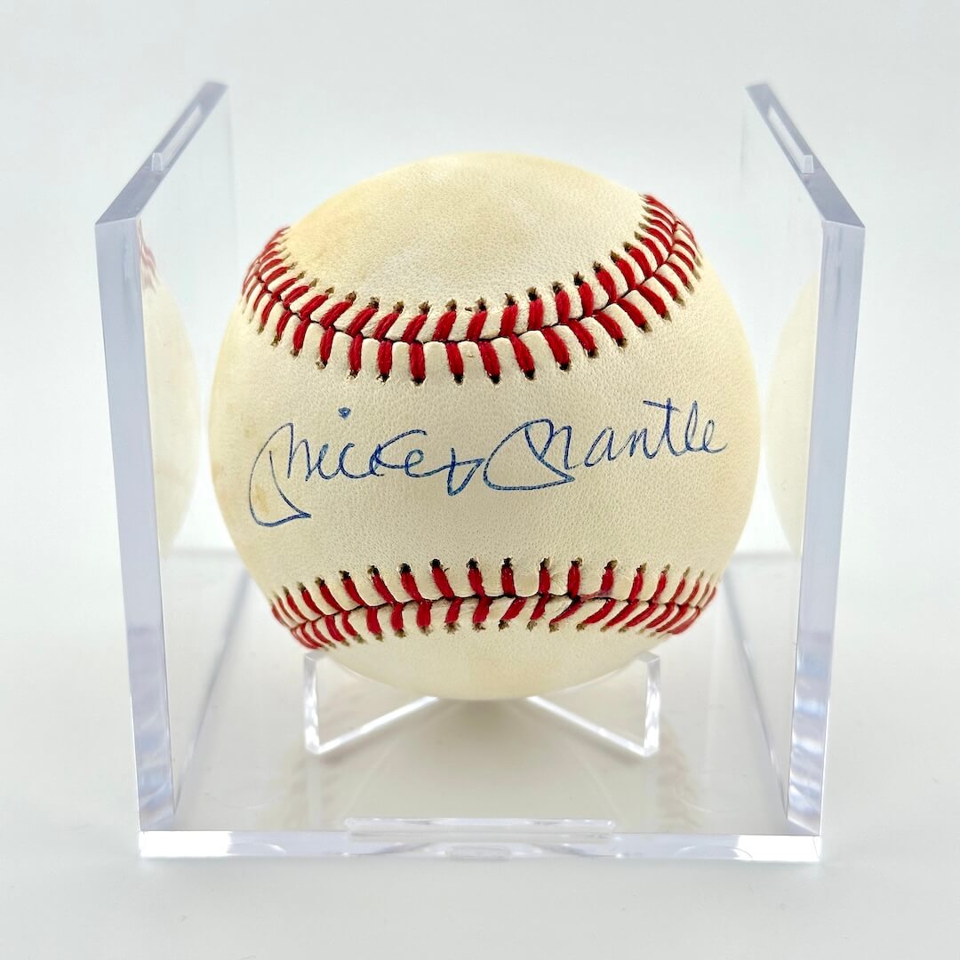 Signed baseball in clear display cube against white background.