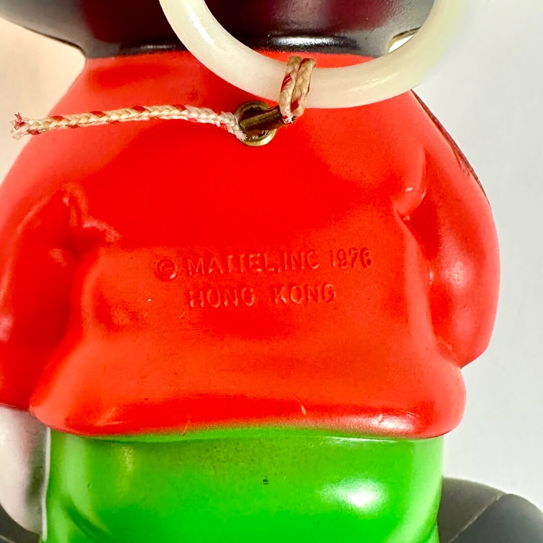 Close-up of a character with a red top and green bottom, featuring a 'Mattel Inc. 1976 Hong Kong' label.
