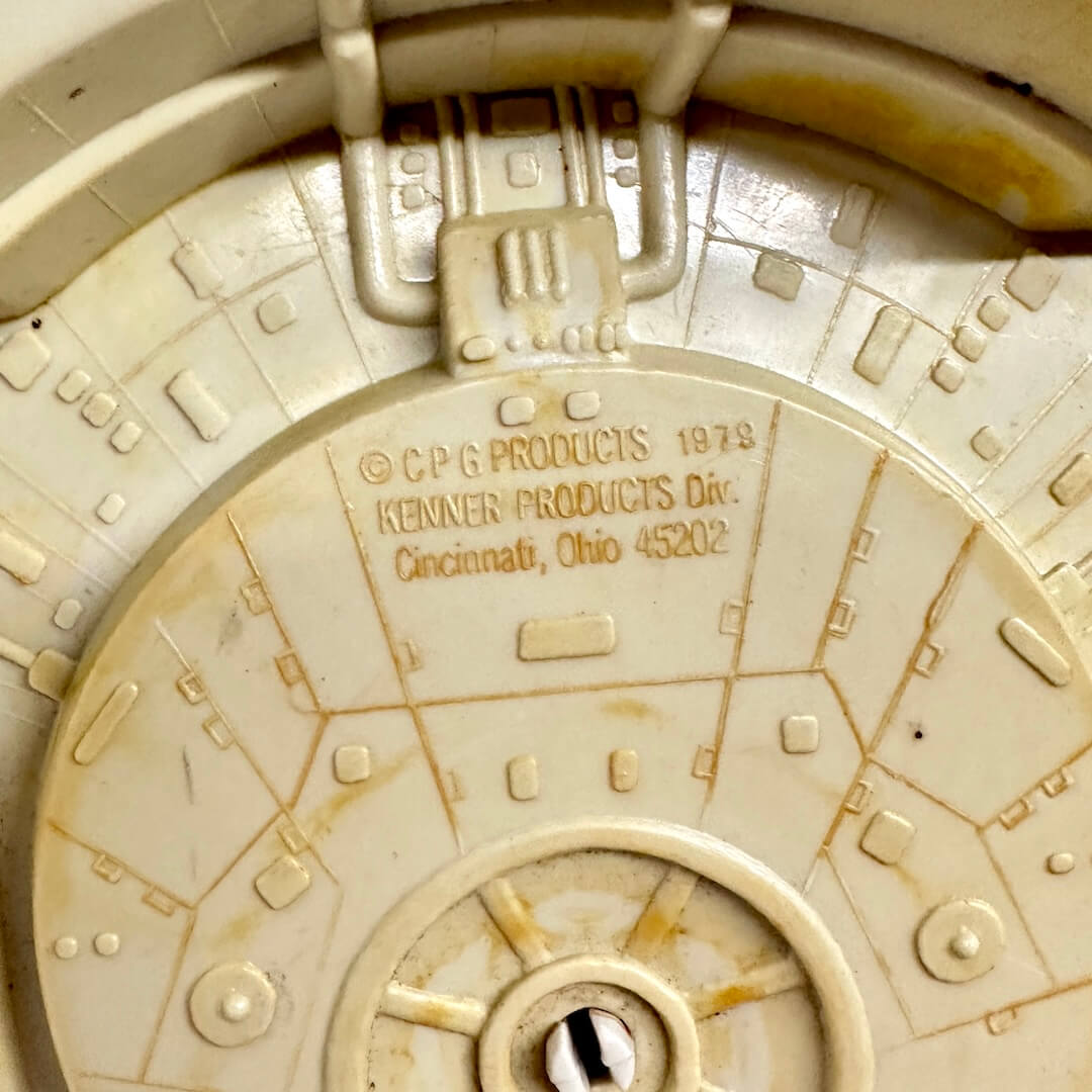 Close-up of a vintage toy Millennium Falcon model with branding details.