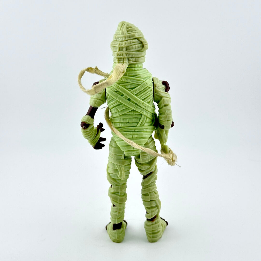Green mummy figurine on a white background