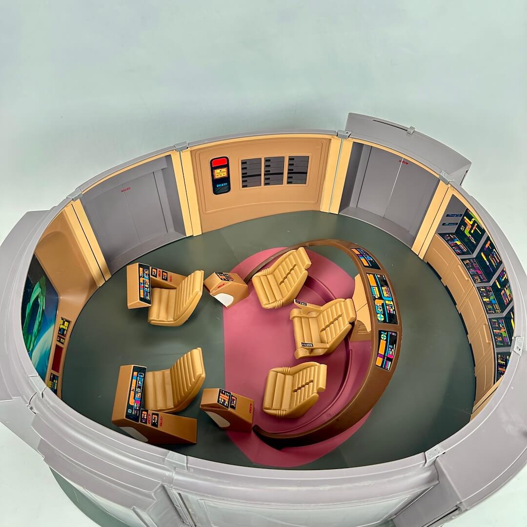 Circular room with futuristic design, including central chairs.