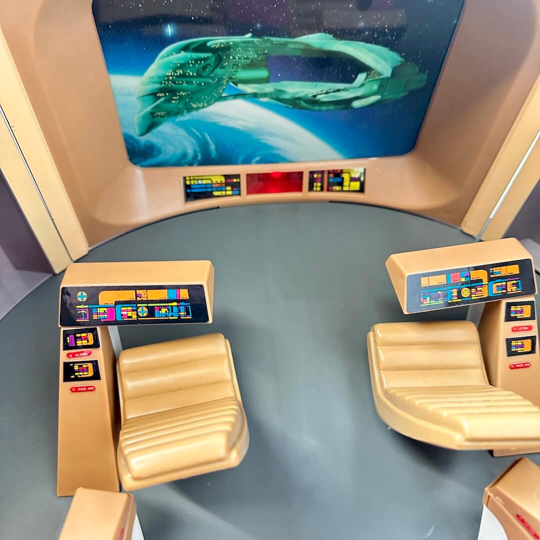 Control panel with futuristic design and screen displaying a spaceship.