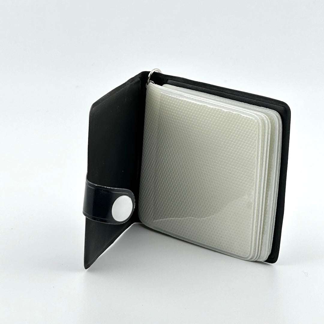 black booklet with snap closure and six photo sleeve pages with zero use or damage.