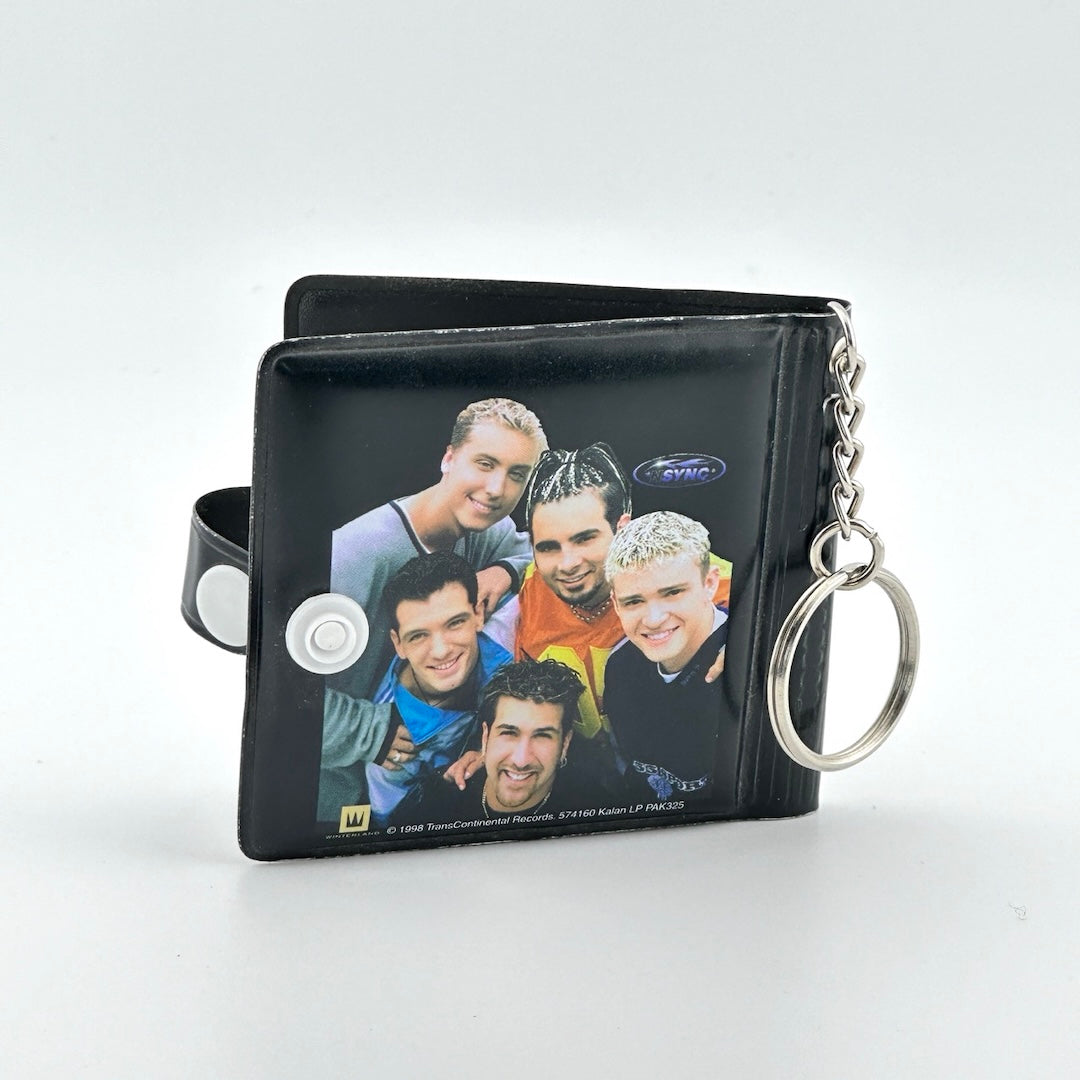 Black book with keychain attachment, snap closure, & image of five members of NYSNC. Back view.