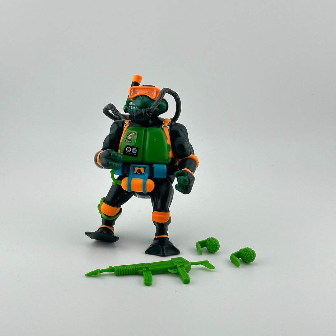 Anthropomorphized turtle in orange scuba mask with orange details on black scuba suit, with green accessories.