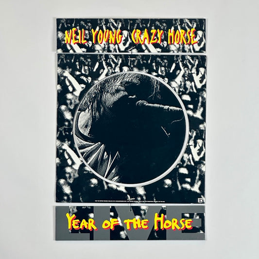 Black/white image of crowd as background for 4pc cardboard mobile. Artist name as top piece, face in center, album as bottom