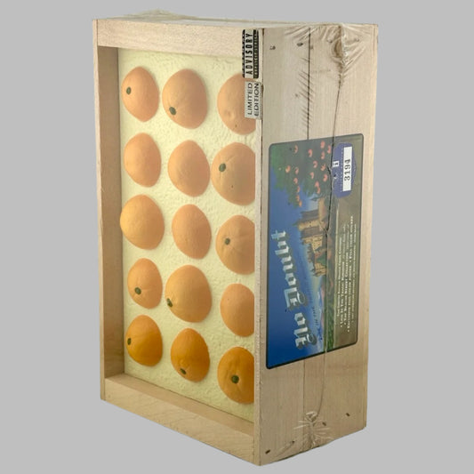 Plastic wrapped wooden fruit crate with blue label on side, & fake oranges in top.