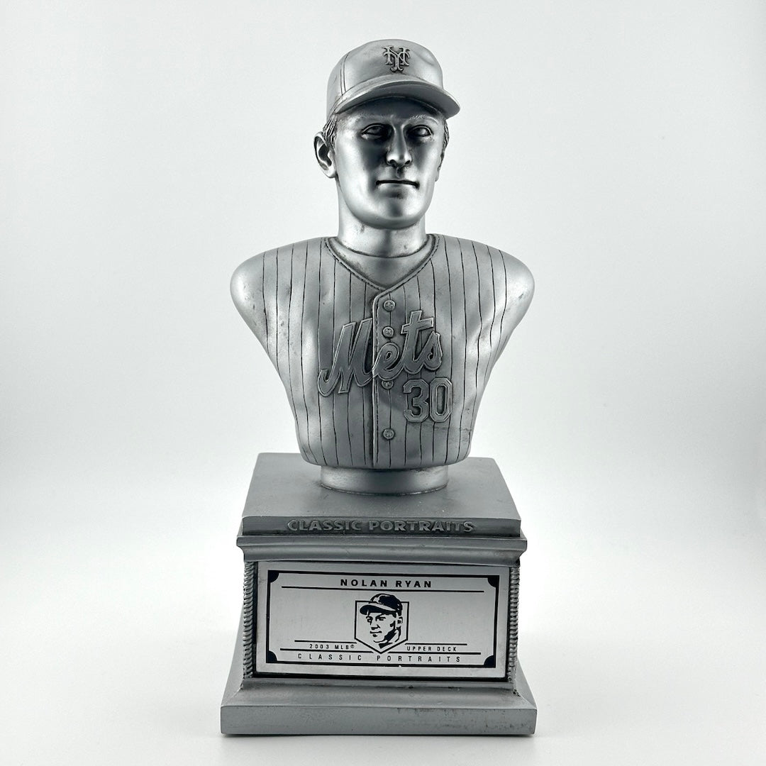 Silver pedestal with silver bust of Nolan Ryan in NY Mets uniform. Silver plaque on pedestal.