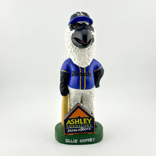 Bobblehead figure of a bird in a blue jacket with 'Ashley Furniture HomeStore' logo on a white background
