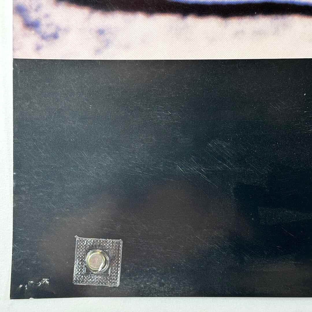 Bottom left corner with pin holes and light scratches.