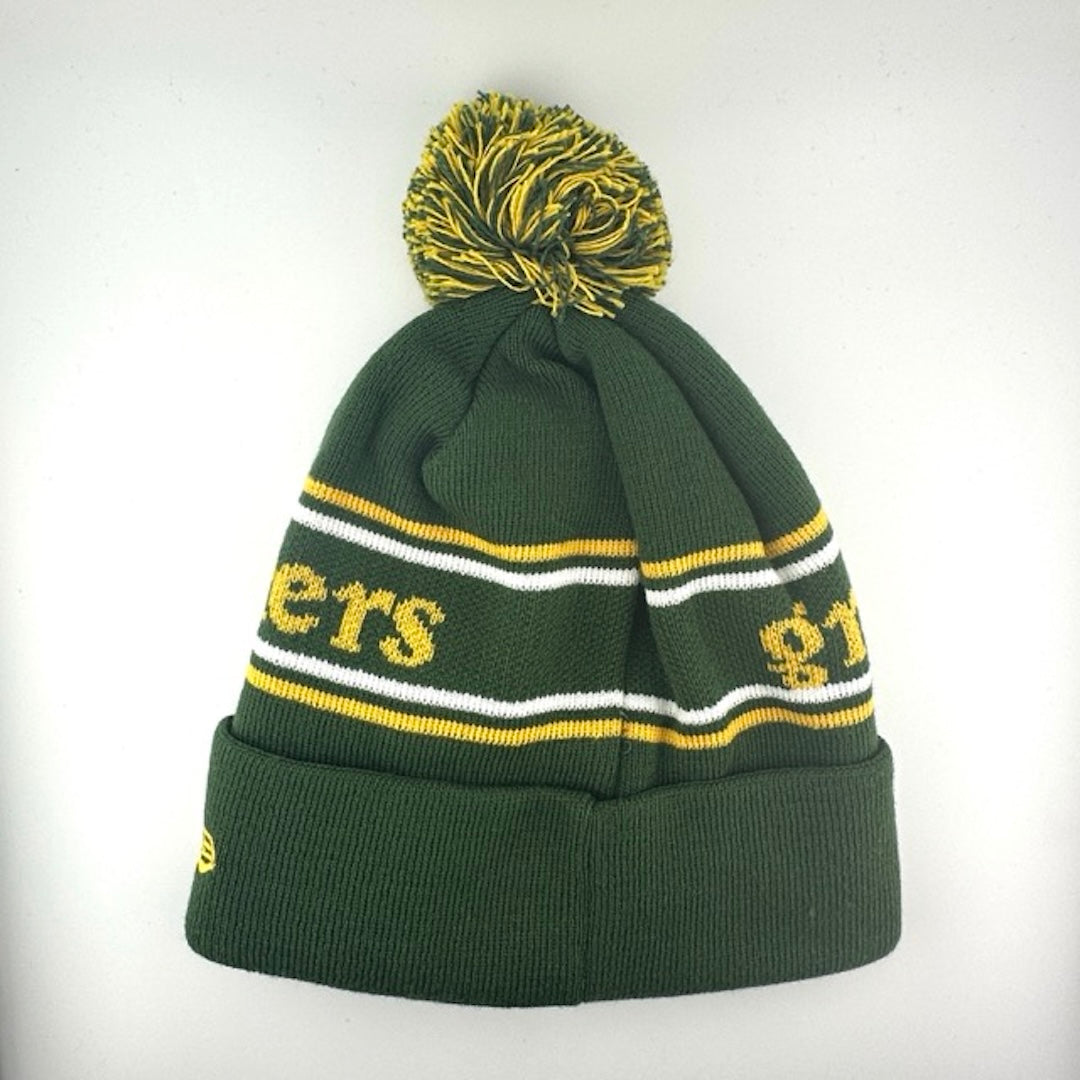 Green knit cap with white/yellow stripes around yellow team name, Packers logo in center of green cuff & green/yellow pom