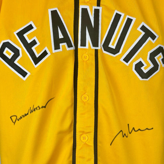 Close up of stitched on "Peanuts" & signatures beneath on either panel next to buttons.