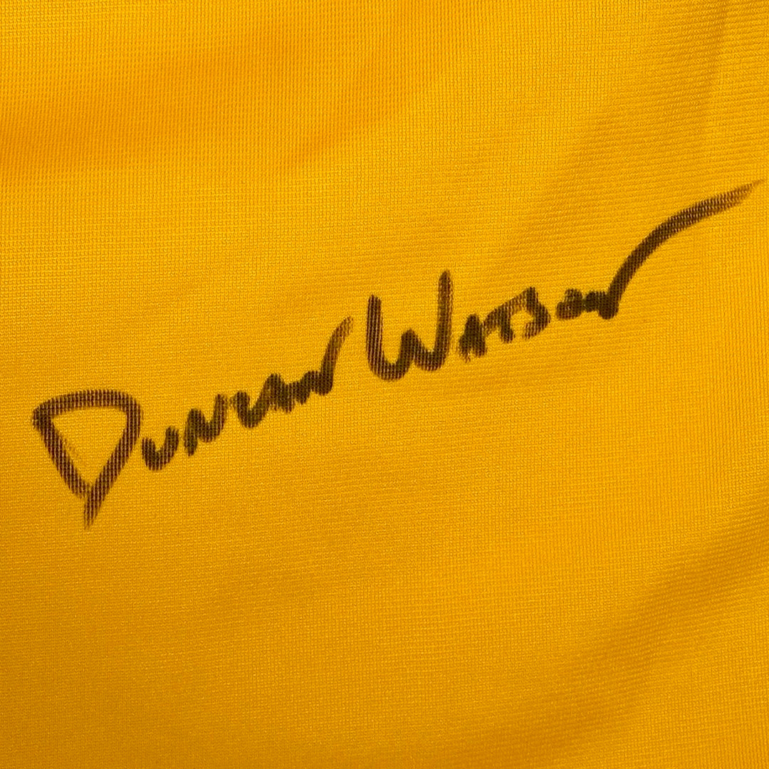 Close up of Duncan Watson's signature in black marker against yellow jersey