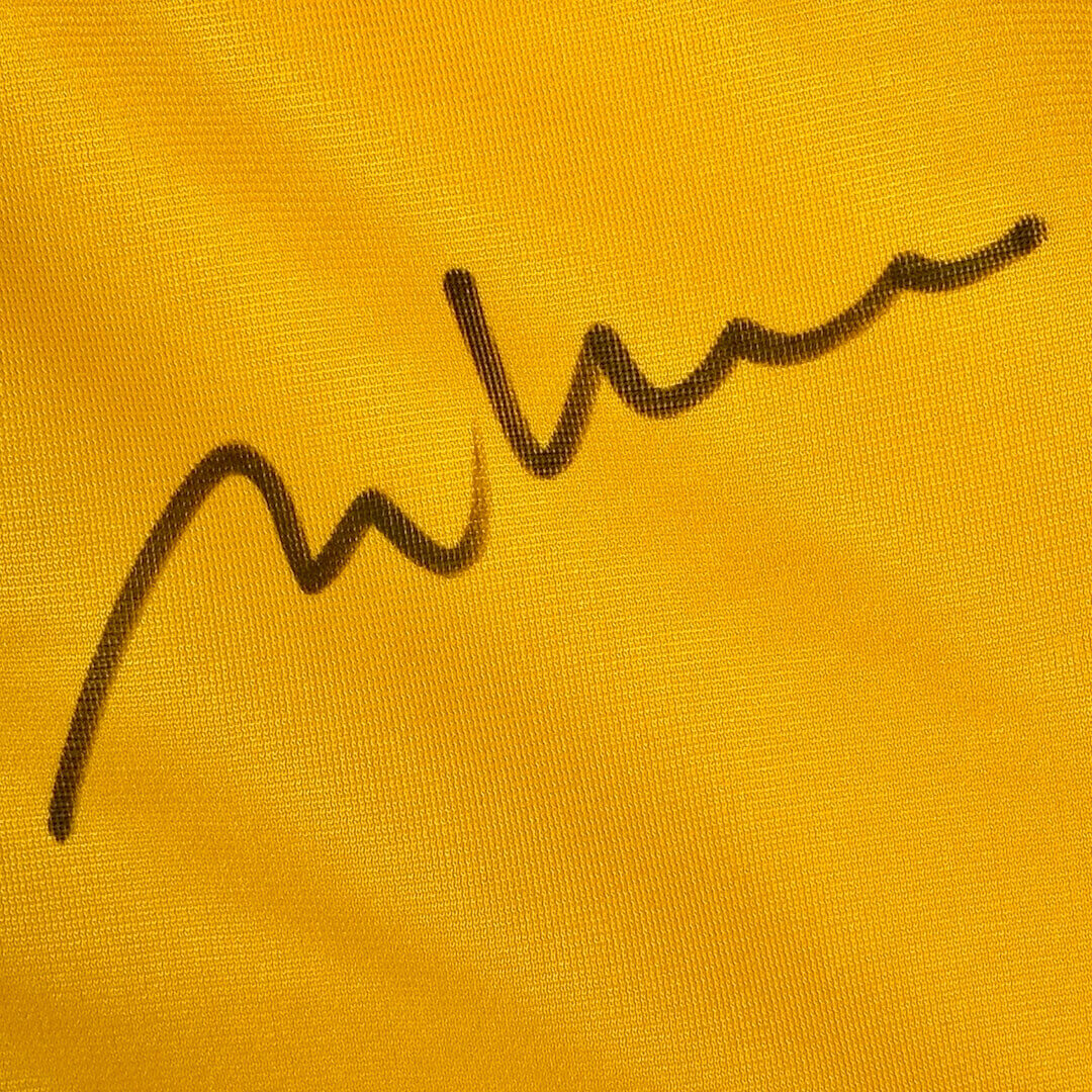 Close up of Melanie Kohn's signature in black marker against yellow jersey