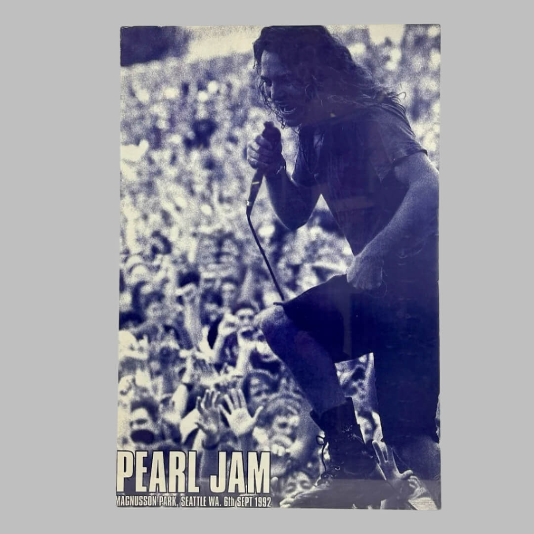 Blue monochromatic photo of Pearl Jam's singer and crowd behind and below him.