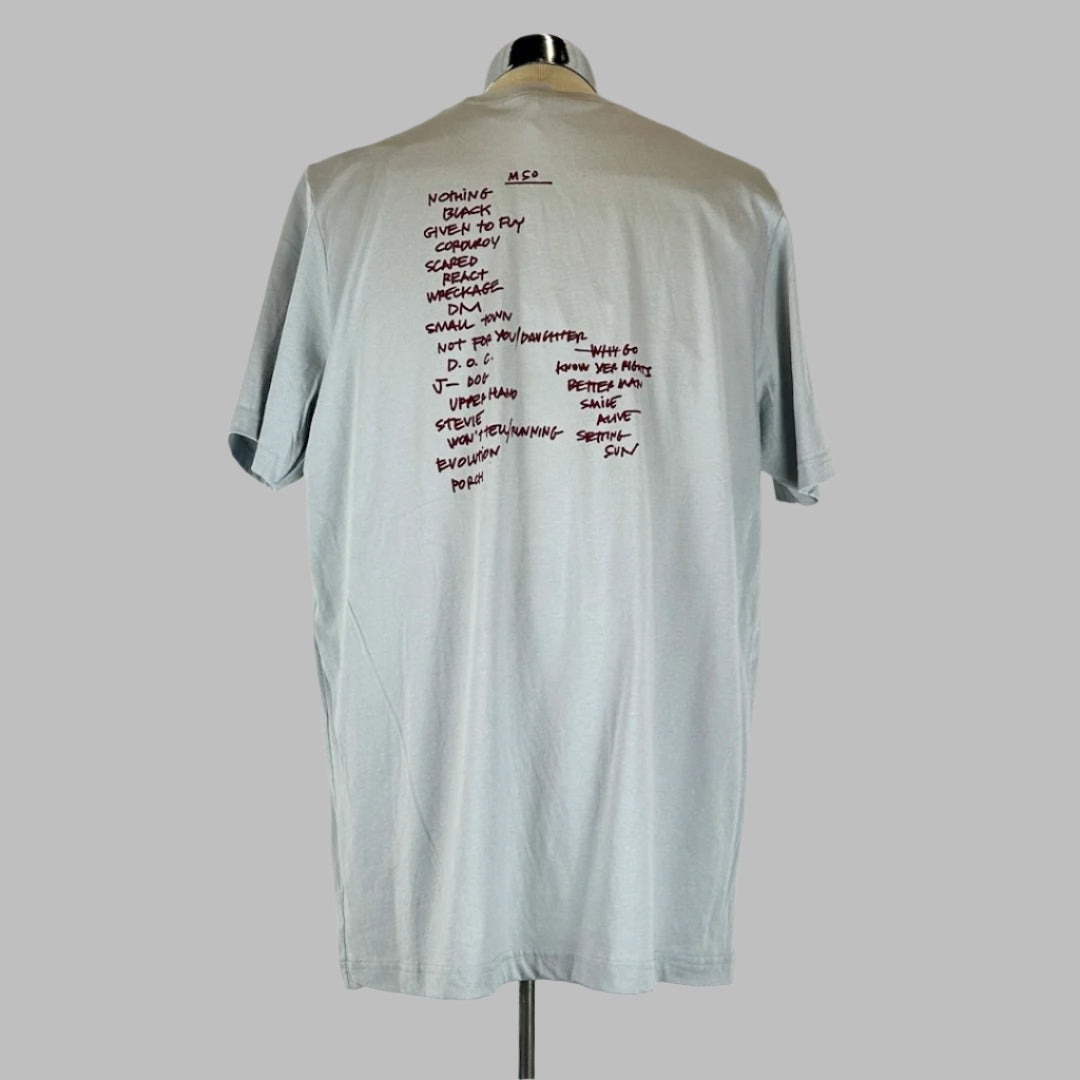 Back of grey shirt with maroon in handwriting style text detailing show set list.