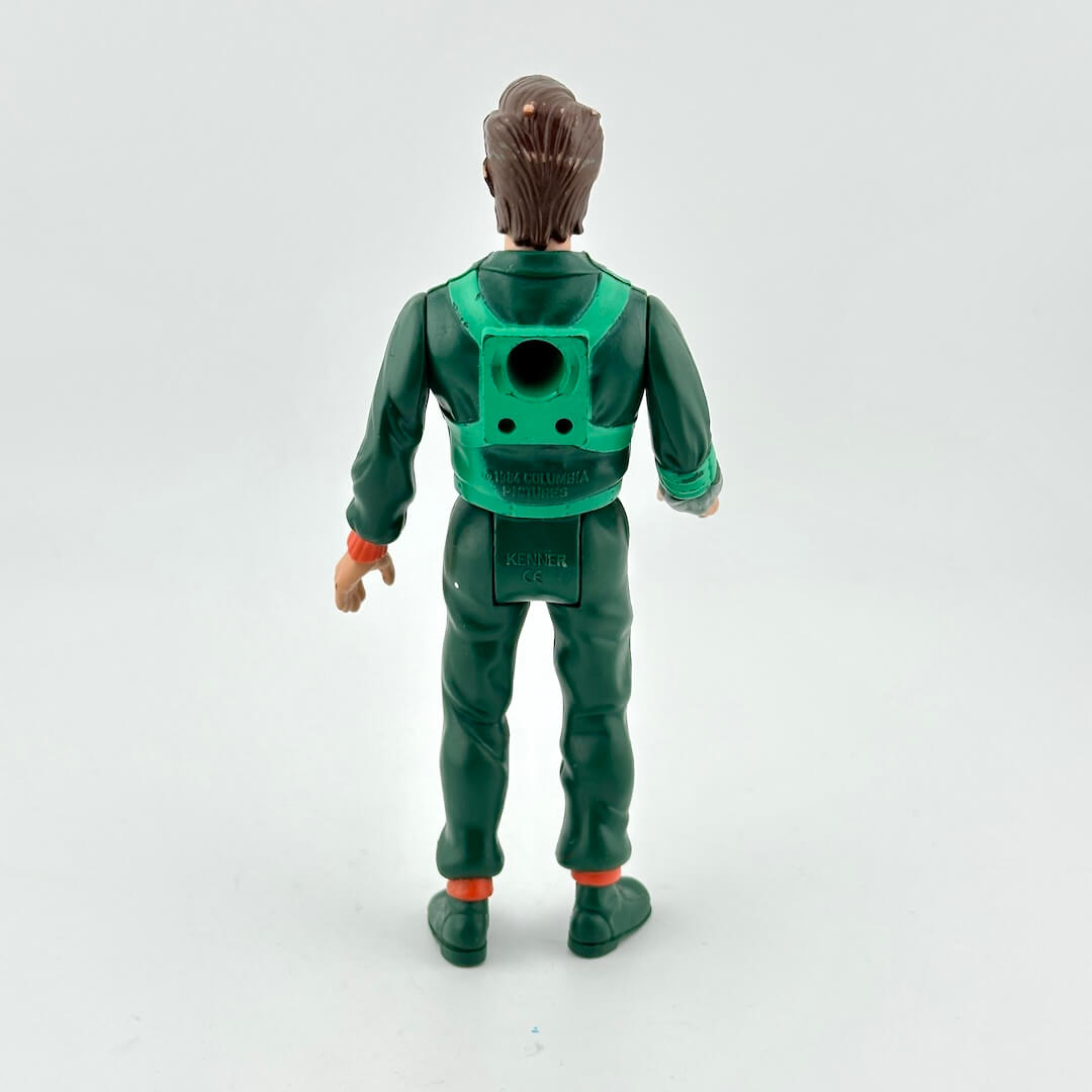 Toy figure in green outfit with backpack on a white background
