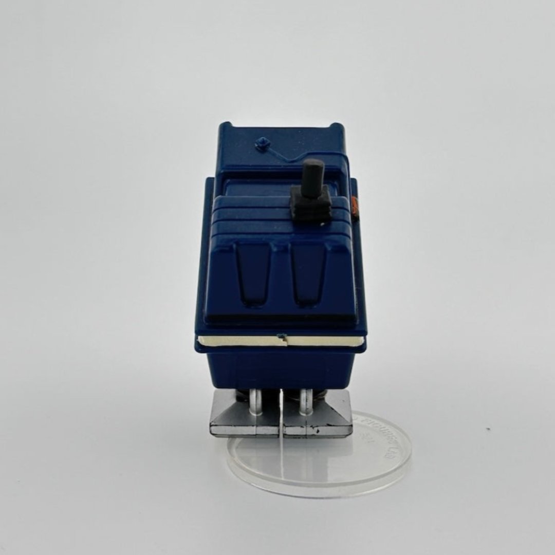 Image of blue box-shaped droid with white stripe around middle, 3 multi-colored buttons on face, grey flat feet.