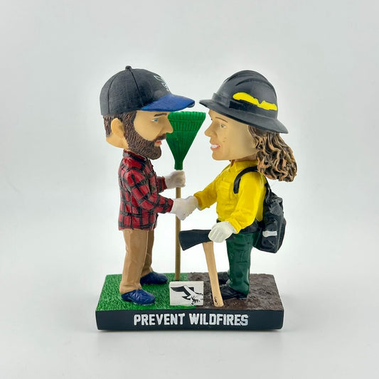 Bobbleheads of a man and woman in outdoor gear with 'Prevent Wildfires' text on a white background