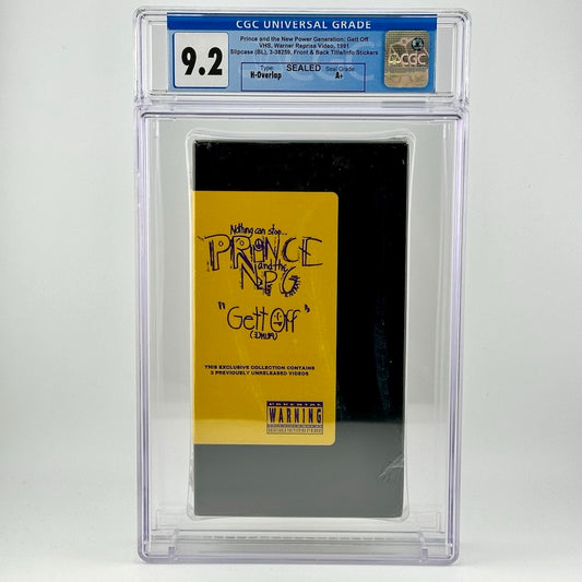 Image of sealed VHS tape in clear plastic case with grading info at top. VHS is black with yellow label with purple print.