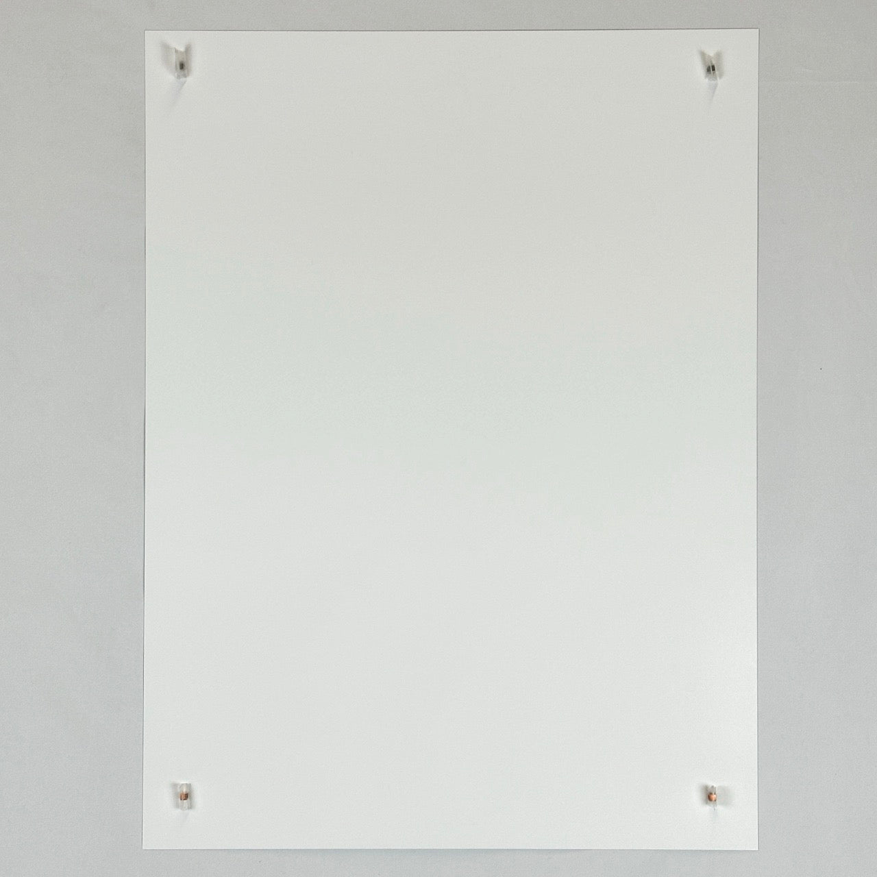 Image of reverse side of poster showing no marks or damage, only white paper held up by small magnets