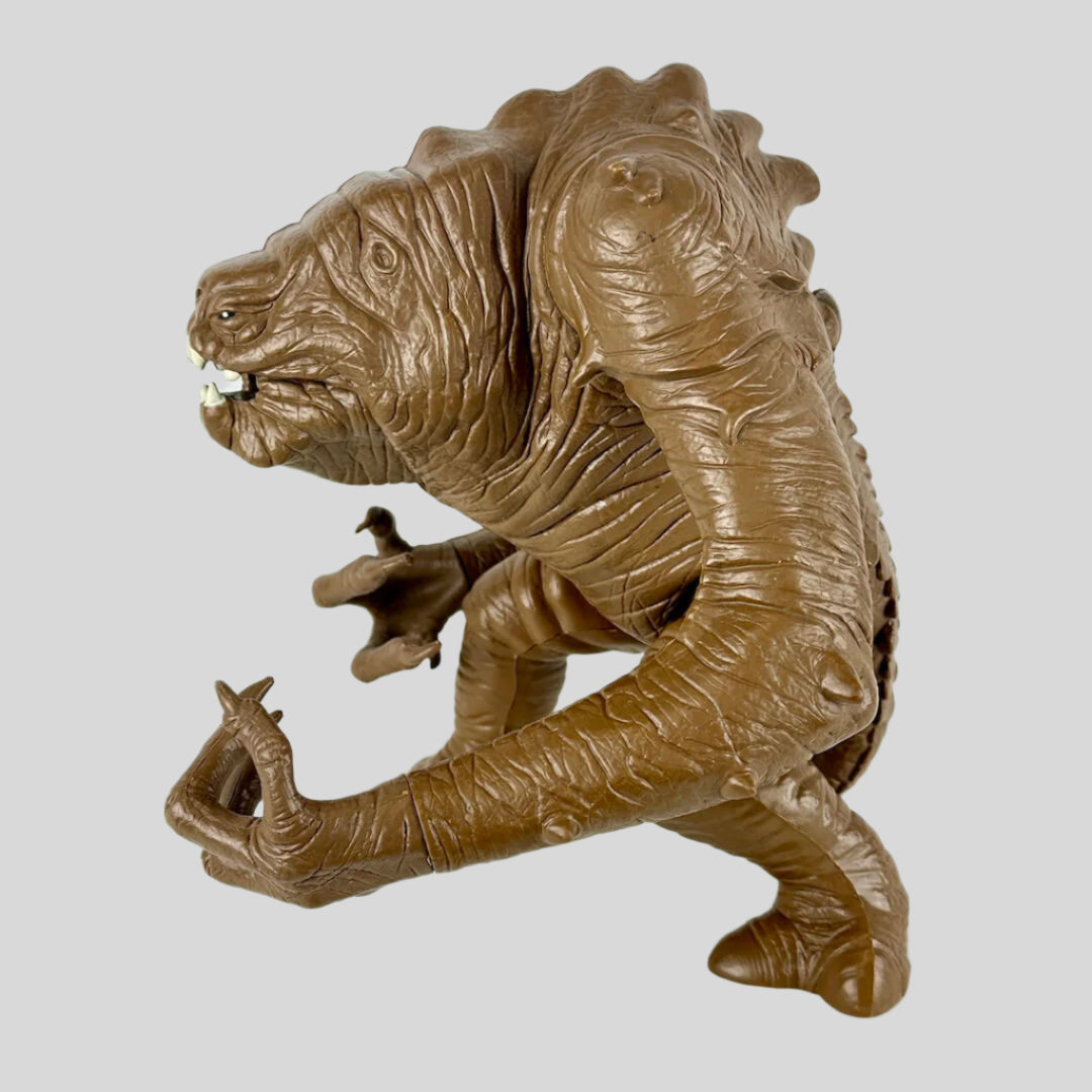 Brown monster-like creature figurine on a white background