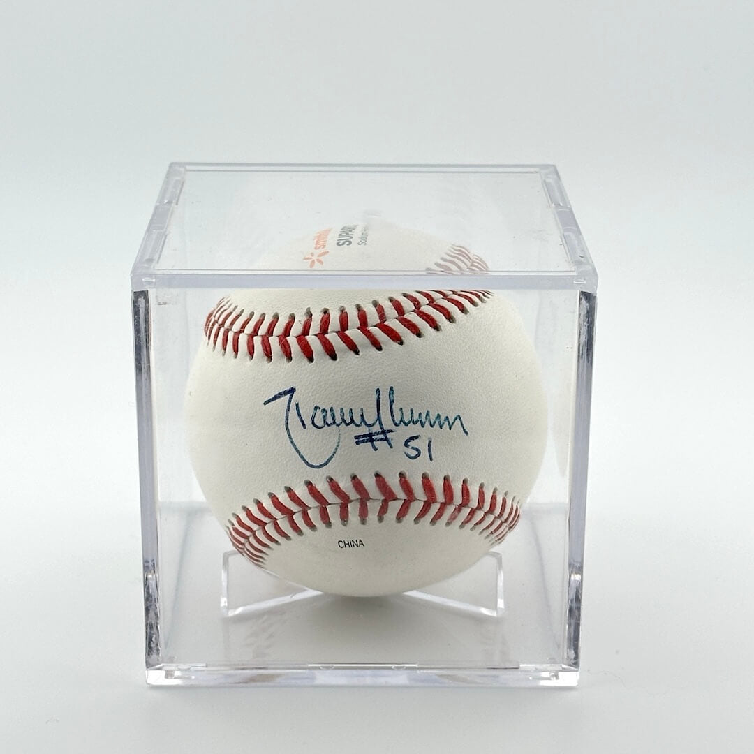 Autographed baseball in plastic cube. Signature in blue pen.