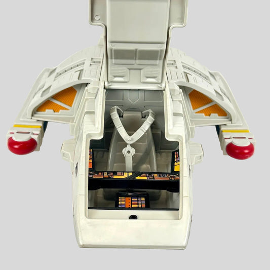 Toy spaceship model with open hatch on a white background