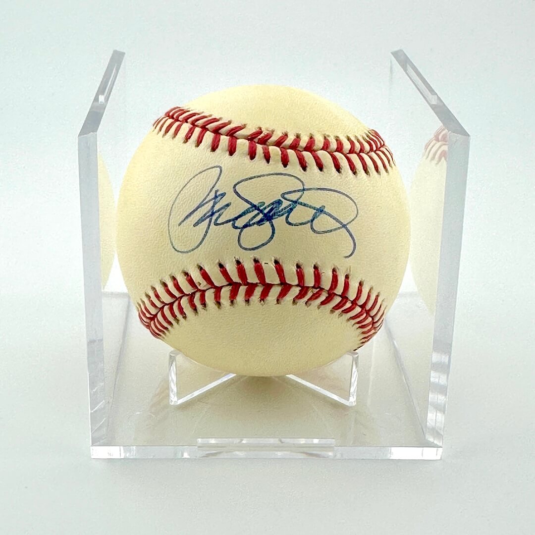 Signed baseball in a clear display case on a white background