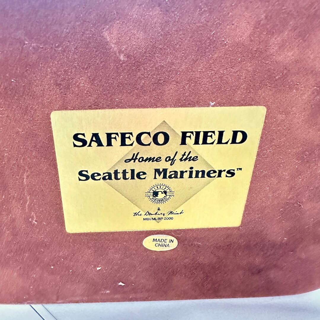 Yellow sticker with 'Safeco Field, Home of the Seattle Mariners' text on a brown background