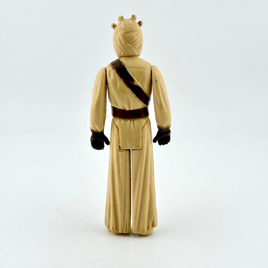 Back of action figure in beige on white background.