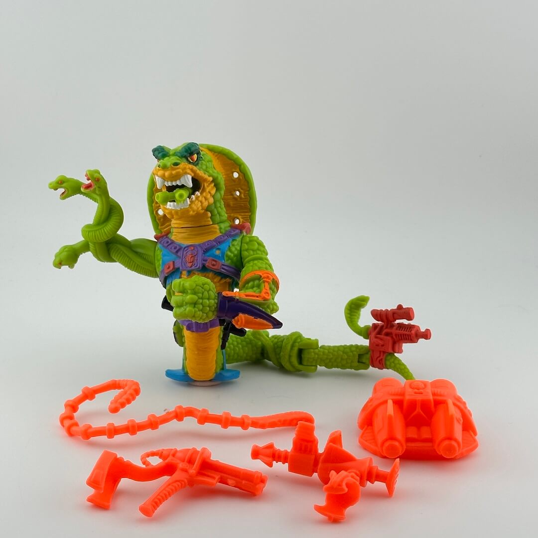 Cobra figure with snakes for one arm, wearing blue/purple harness, pictured with bright orange accessories.