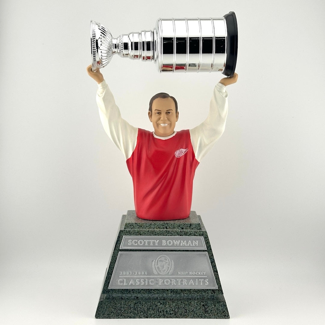 Faux marble pedestal with silver plaques, hockey player on top from stomach up, holding trophy above head.