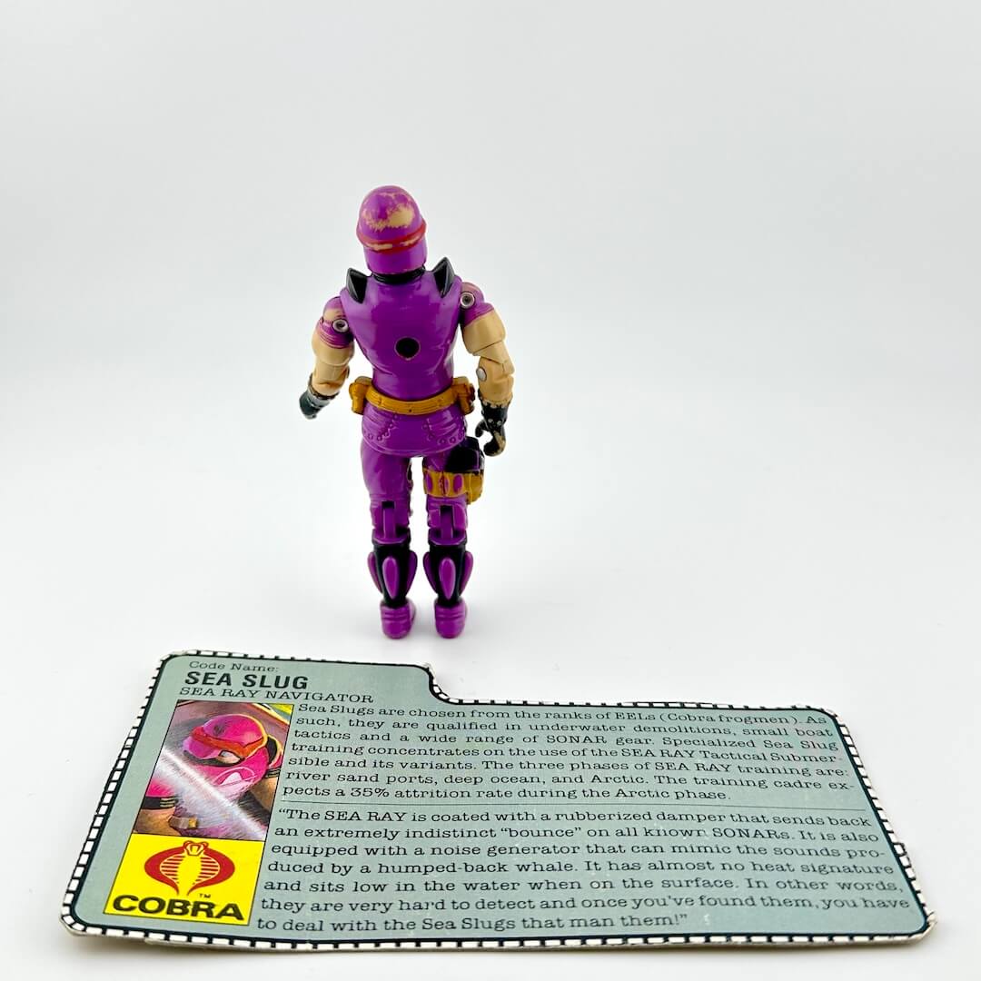 Action figure in purple and yellow costume with a card detailing information about Sea Ray Navigators on a white background