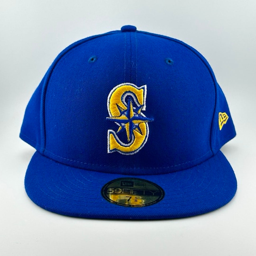 Baseball cap with blue face, brim & back. Gold, white & blue Seattle Mariners logo center-face. Gold sticker on brim.