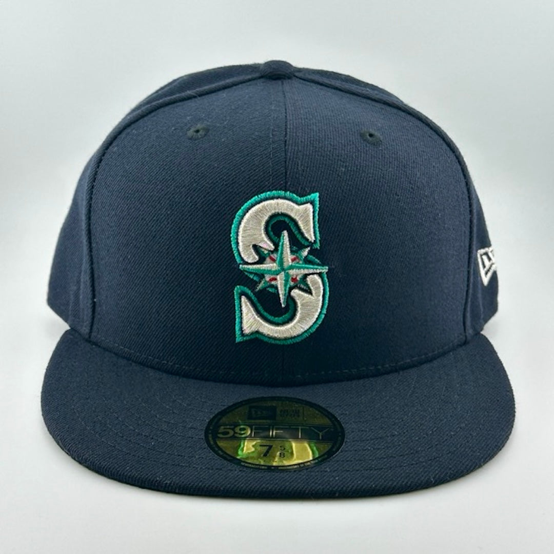 Baseball cap with navy face, brim & back. Teal, white & red Seattle Mariners logo center-face. Gold sticker on brim.