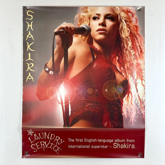 Promotional poster for Shakira's 'Laundry Service' album with a woman holding a microphone.