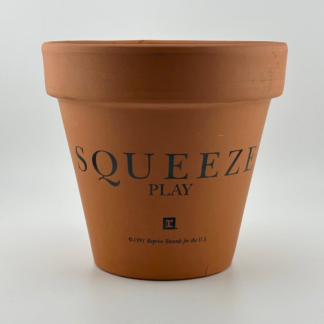 Terracotta clay flower/plant pot with Squeeze, Play, & Reprise Record copyright info printed on side.
