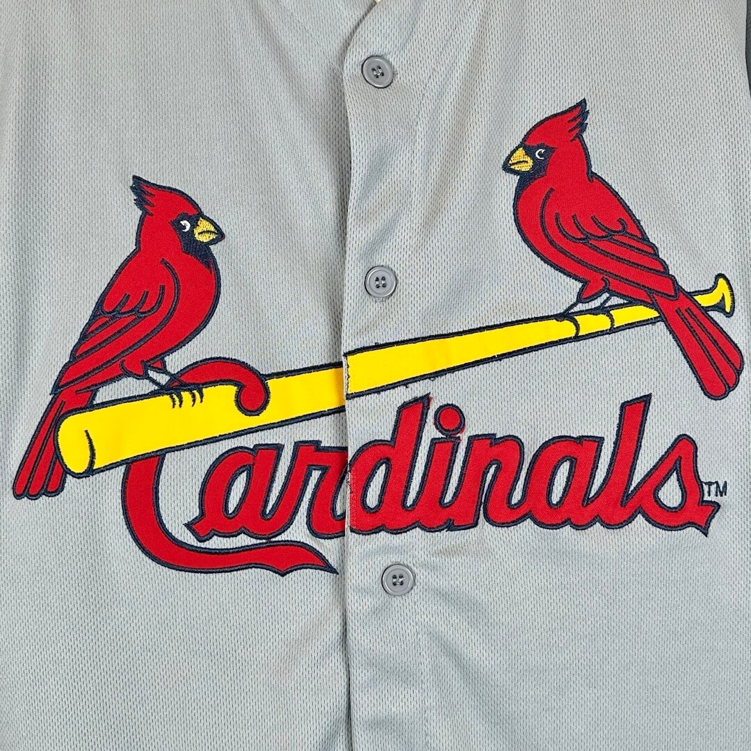 Two red cardinals on a yellow baseball bat with the word Cardinals under in red.