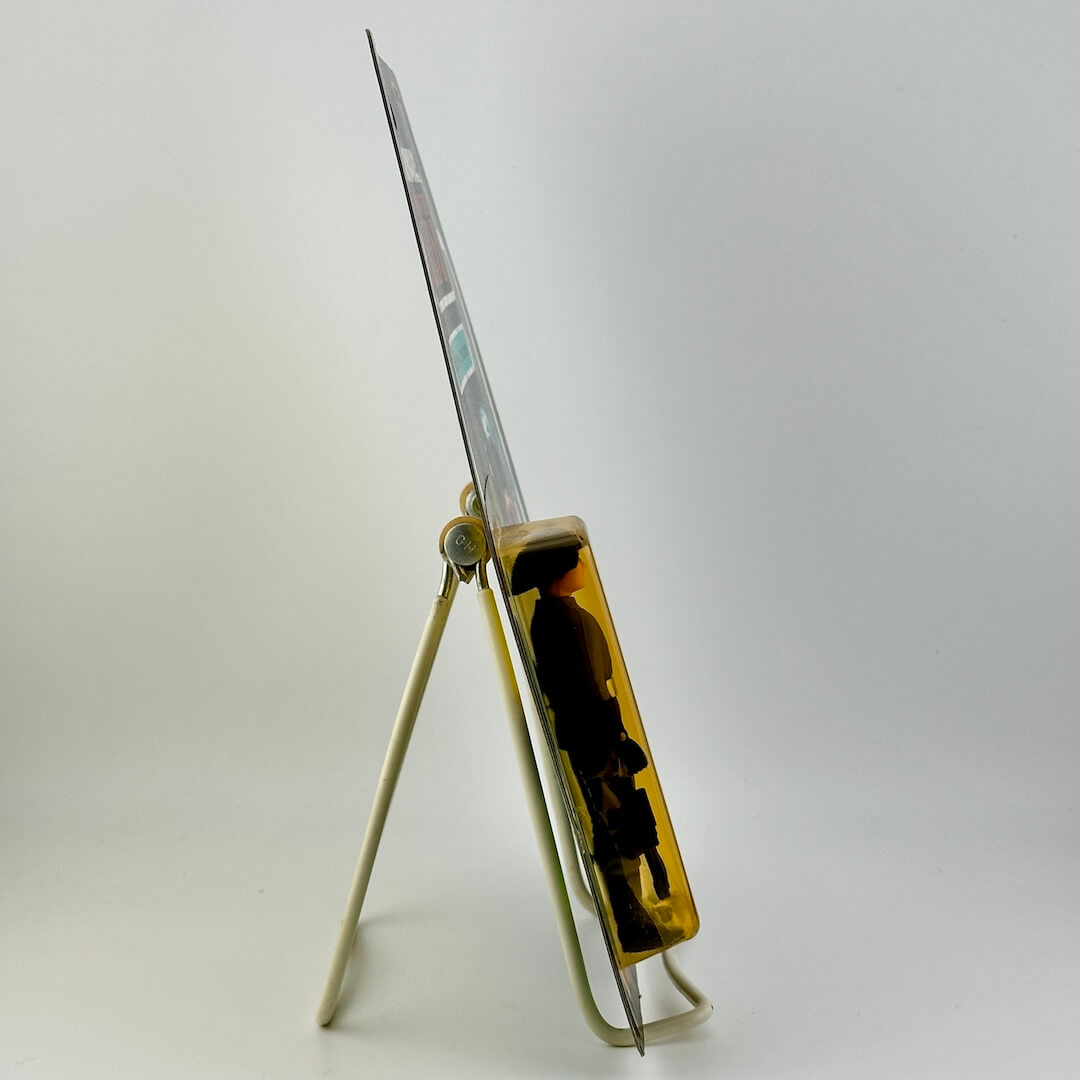Side view of Star Wars action figure in packaging on easel against white background.
