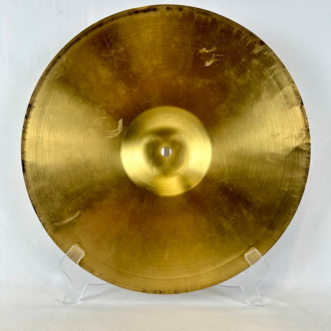 Back side of gold metal cymbal with scuffs.
