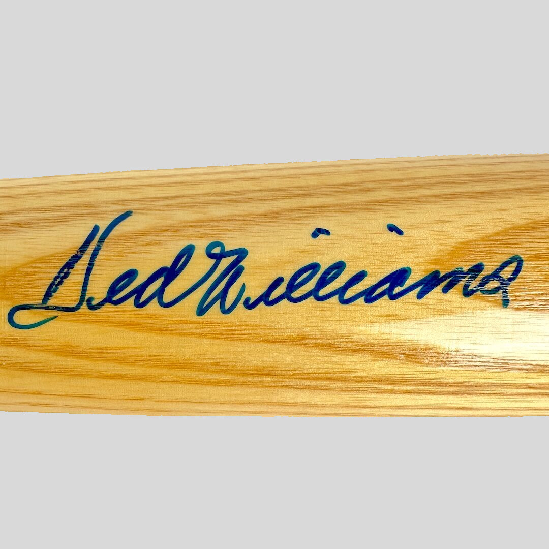 Wooden bat with blue signature on a beige background